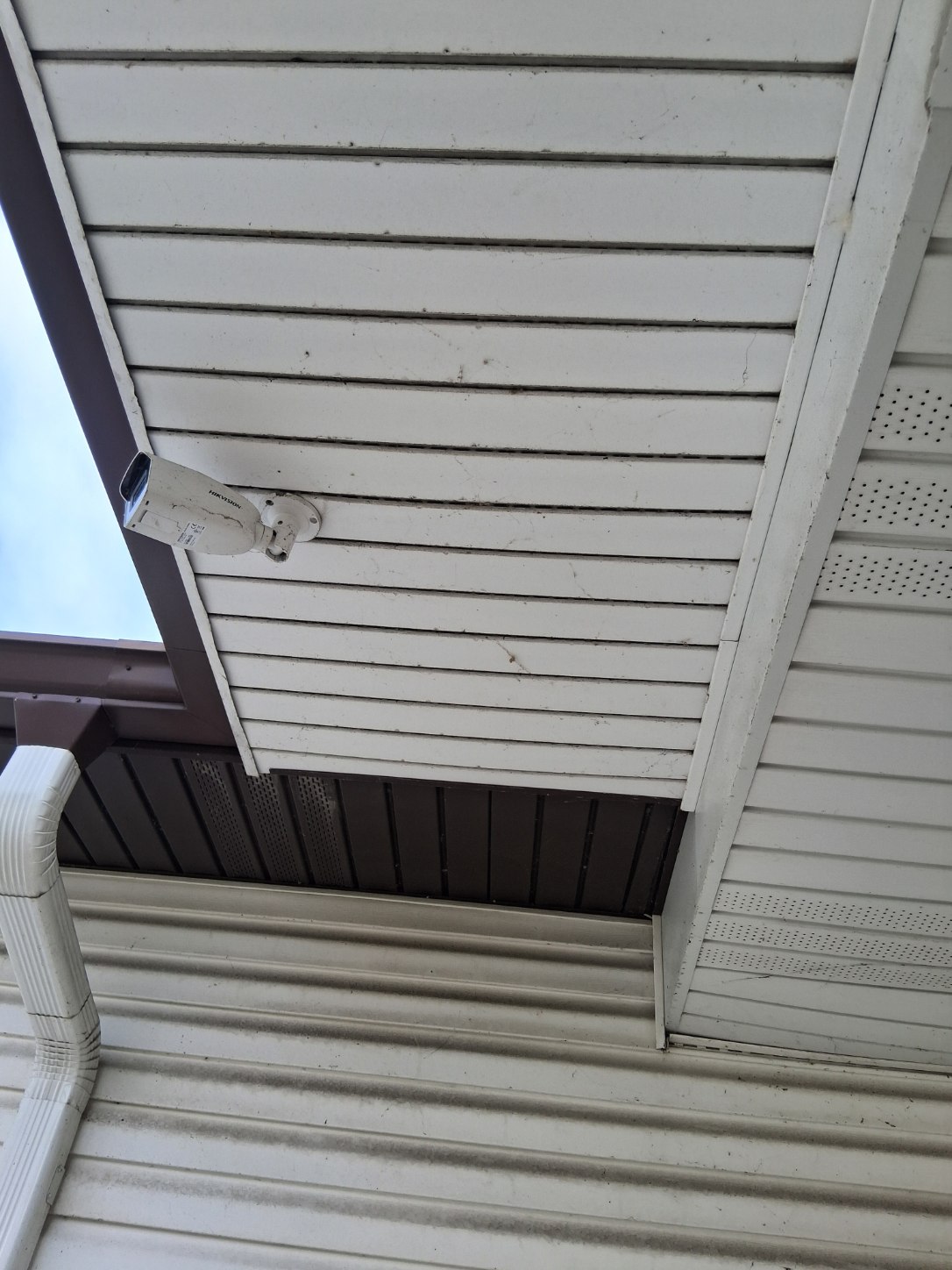 Worker pressure washing house exterior